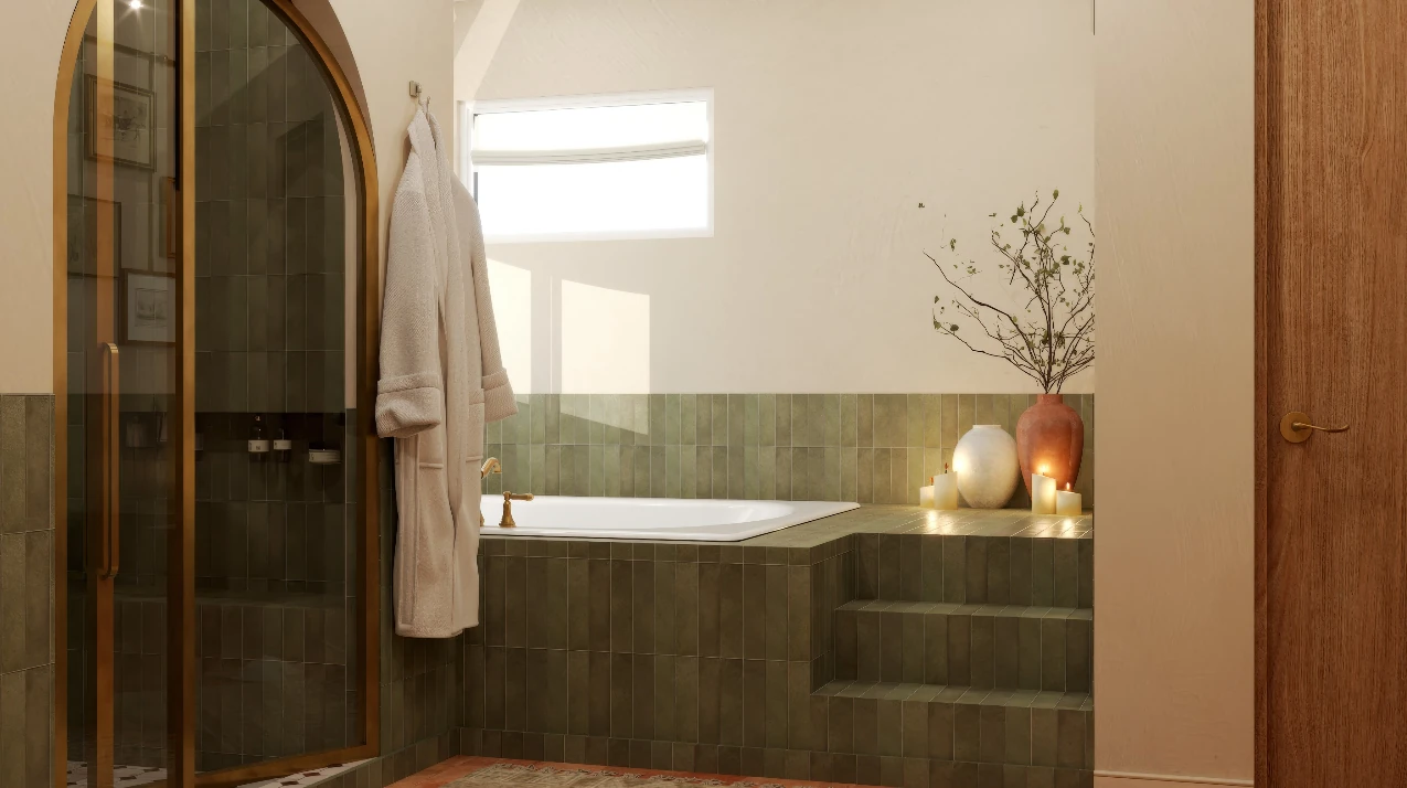 Olive zellige tiled tub deck lit by candles, with a terracotta vase and a robe on a wall hook