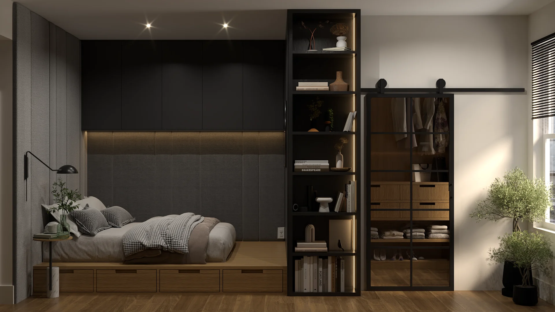 Full studio apartment view showing dark bedroom with platform bed on the left, black bookshelf room divider in the center, and oak walk-in closet with sliding glass barn door on the right