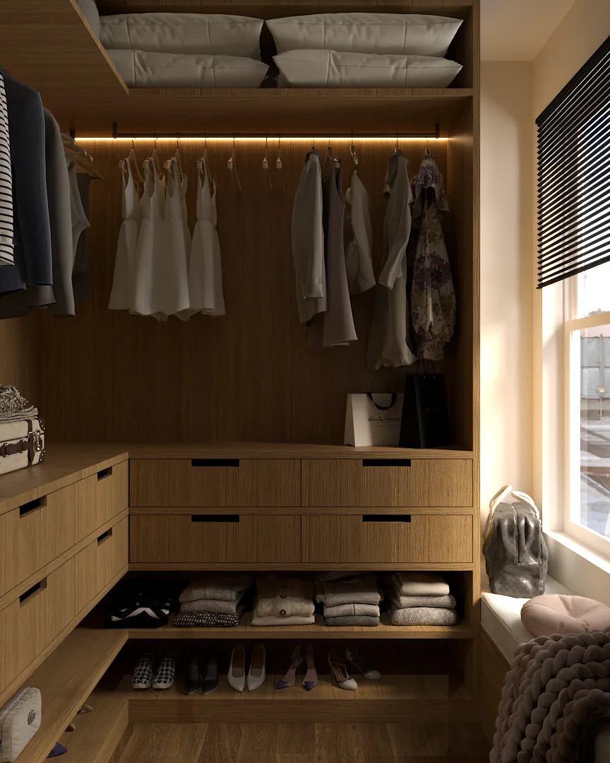 Walk-in closet with pillows stored above, hanging blouses and dresses under LED strip, oak drawers with black handles, folded knitwear and shoes on open shelves, window seat with chunky knit throw visible on the right