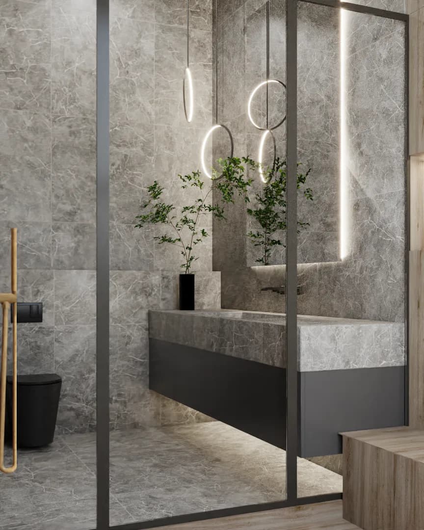 Gray marble vanity with dark cabinet base, ring pendant lights, seen through glass partition