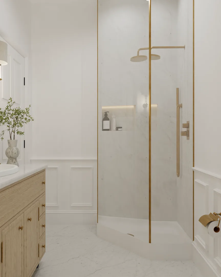 Walk-in shower with gold-framed glass enclosure and marble slab walls