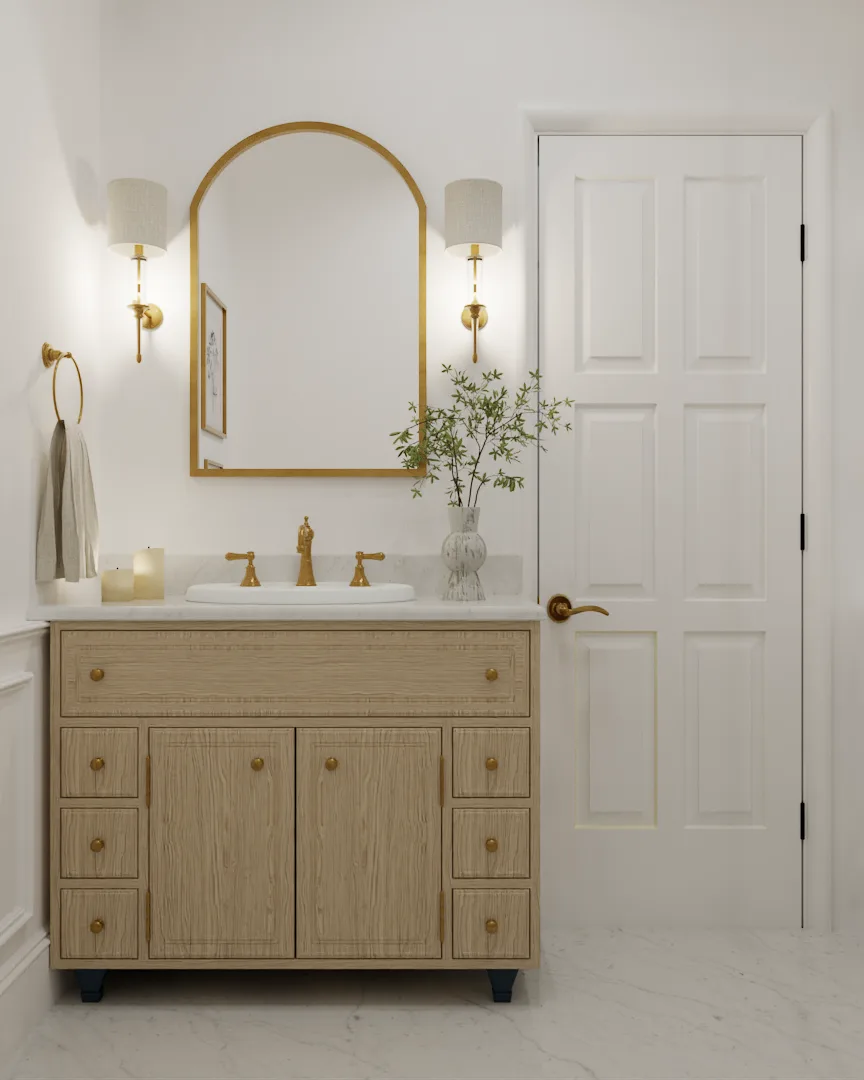 Oak vanity with wide-spread gold faucet, arched mirror, and paired sconces
