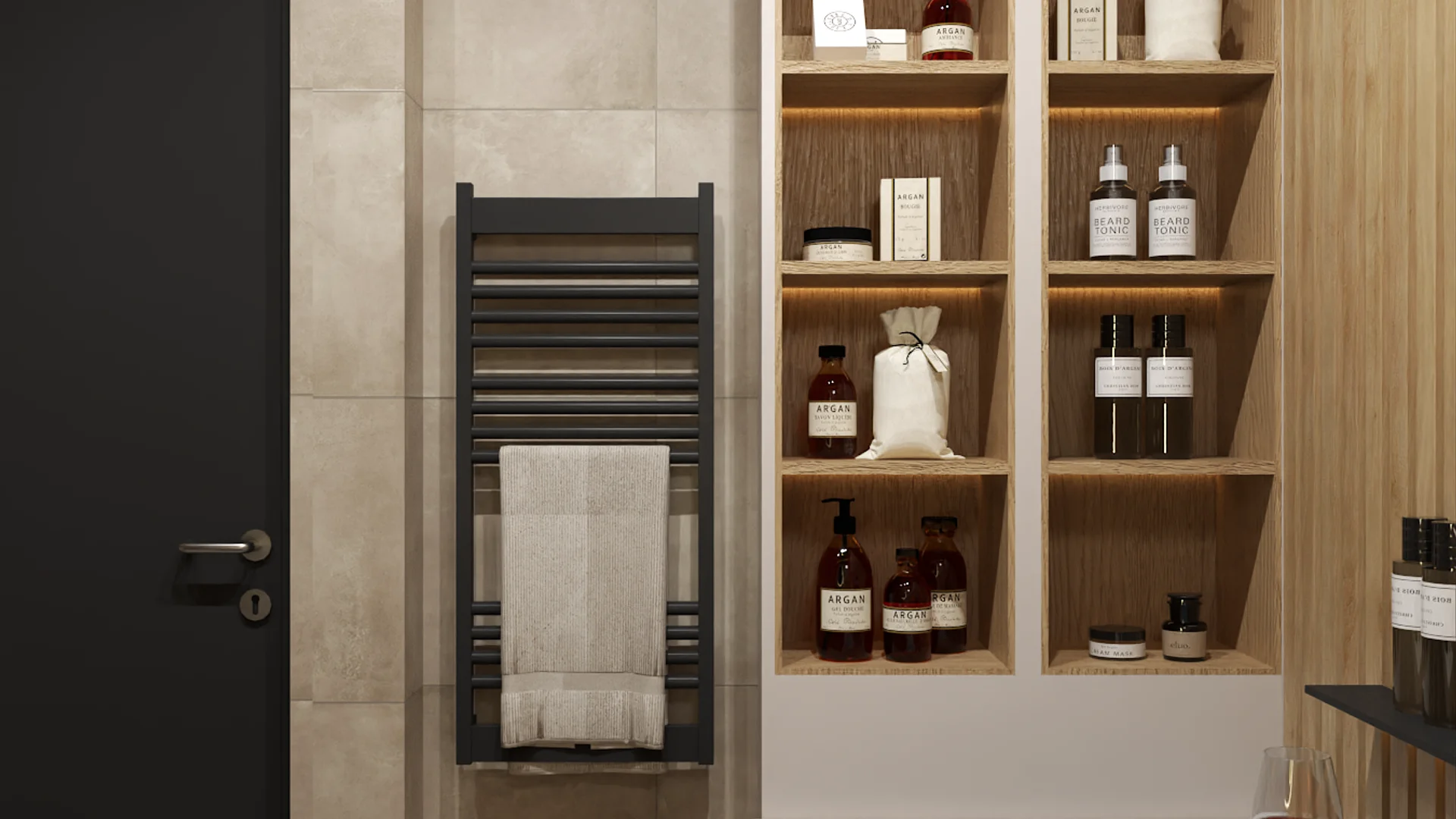 Built-in open oak shelving with LED lighting displaying bath products and linen bags beside a matte black towel radiator with white towel, set against large-format beige stone-look wall tiles with a dark charcoal door to the left