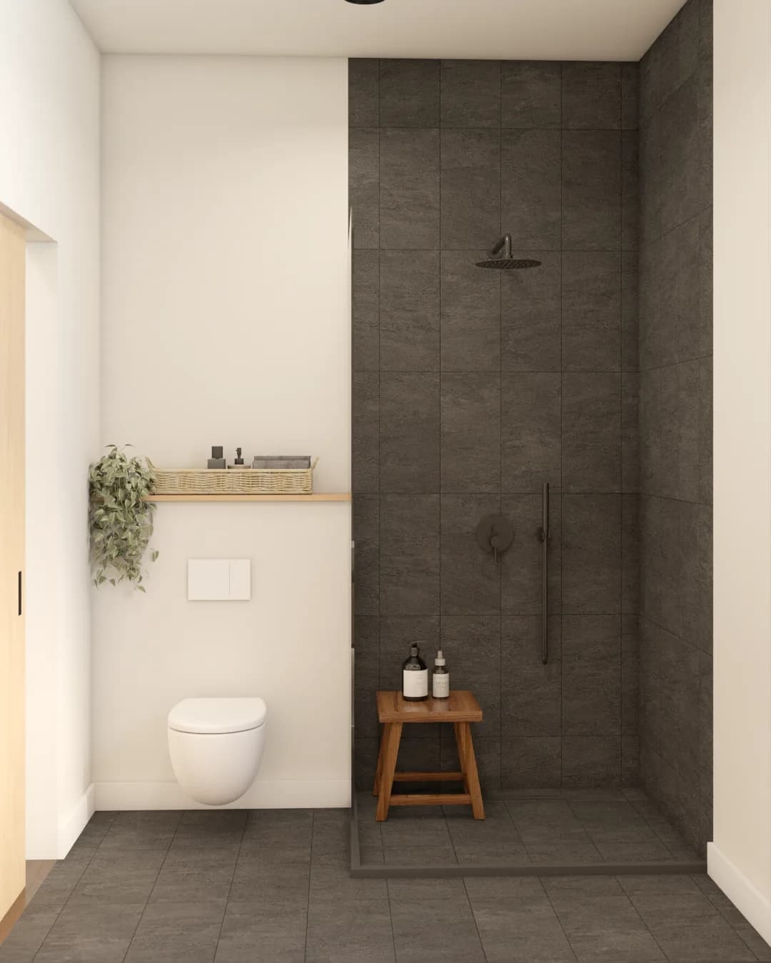 Guest bathroom with dark charcoal tile walls and floor, black-frame glass shower partition, wall-hung toilet, and walnut