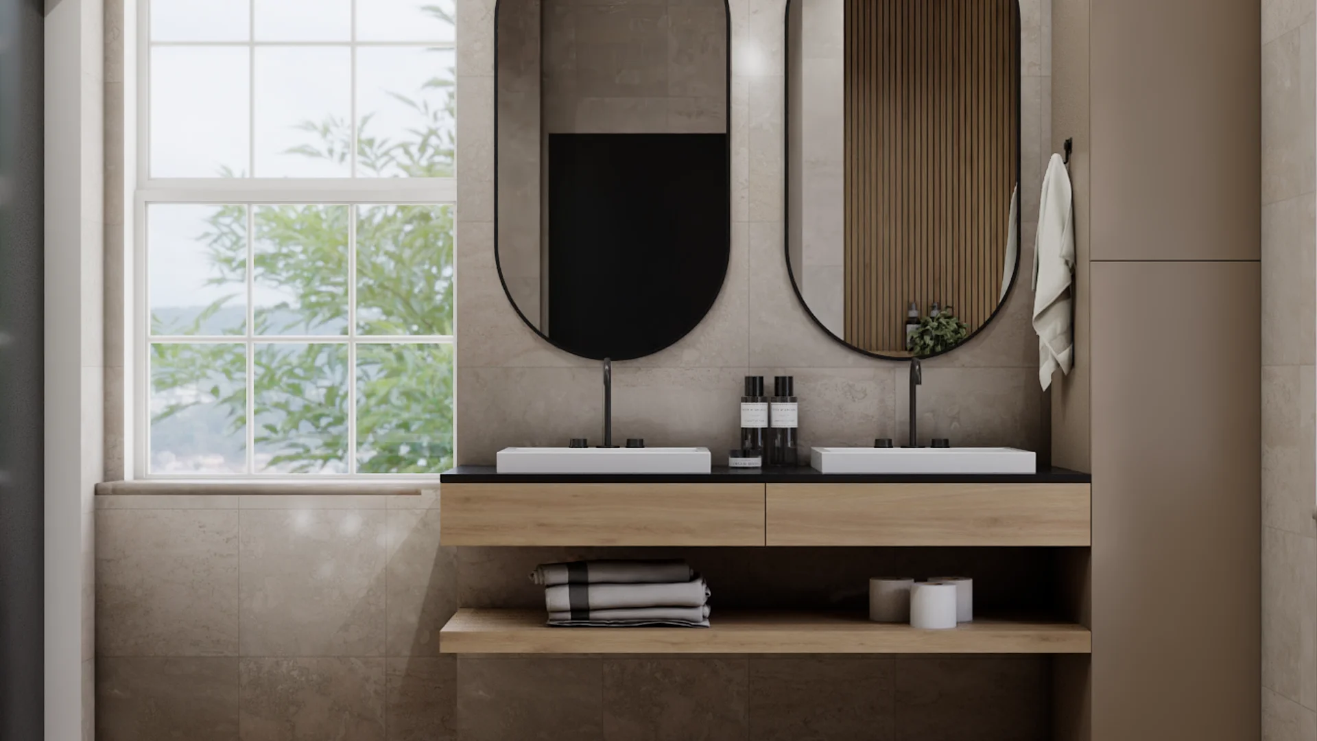 Double bathroom vanity with floating oak cabinet, matte black countertop, two white rectangular vessel sinks, oval black-framed mirrors, vertical wood slat accent wall panel, and large-format taupe stone tiles. Design by Debora, an online interior design service.
