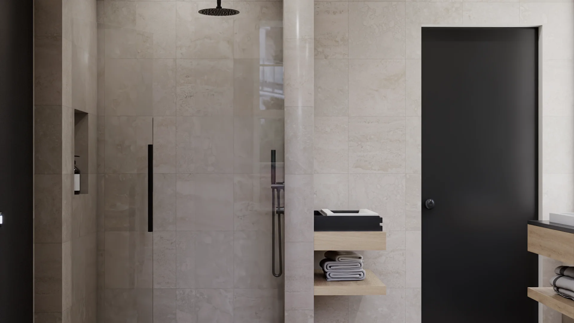 Walk-in shower interior with ceiling-mounted matte black round rain head, handheld shower on slide bar, large-format limestone tile walls and floor, recessed niche with toiletry bottle, black-framed glass door, floating oak shelves with folded towels outside