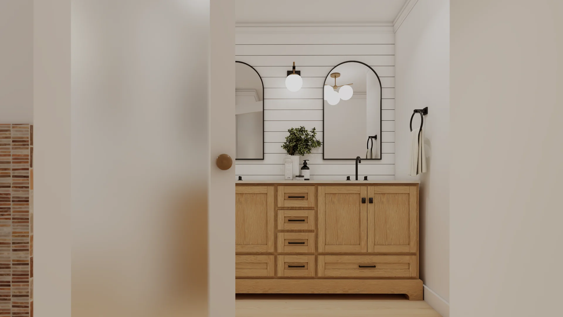 Oak shaker double vanity with twin arched black mirrors and white shiplap wall seen through doorway