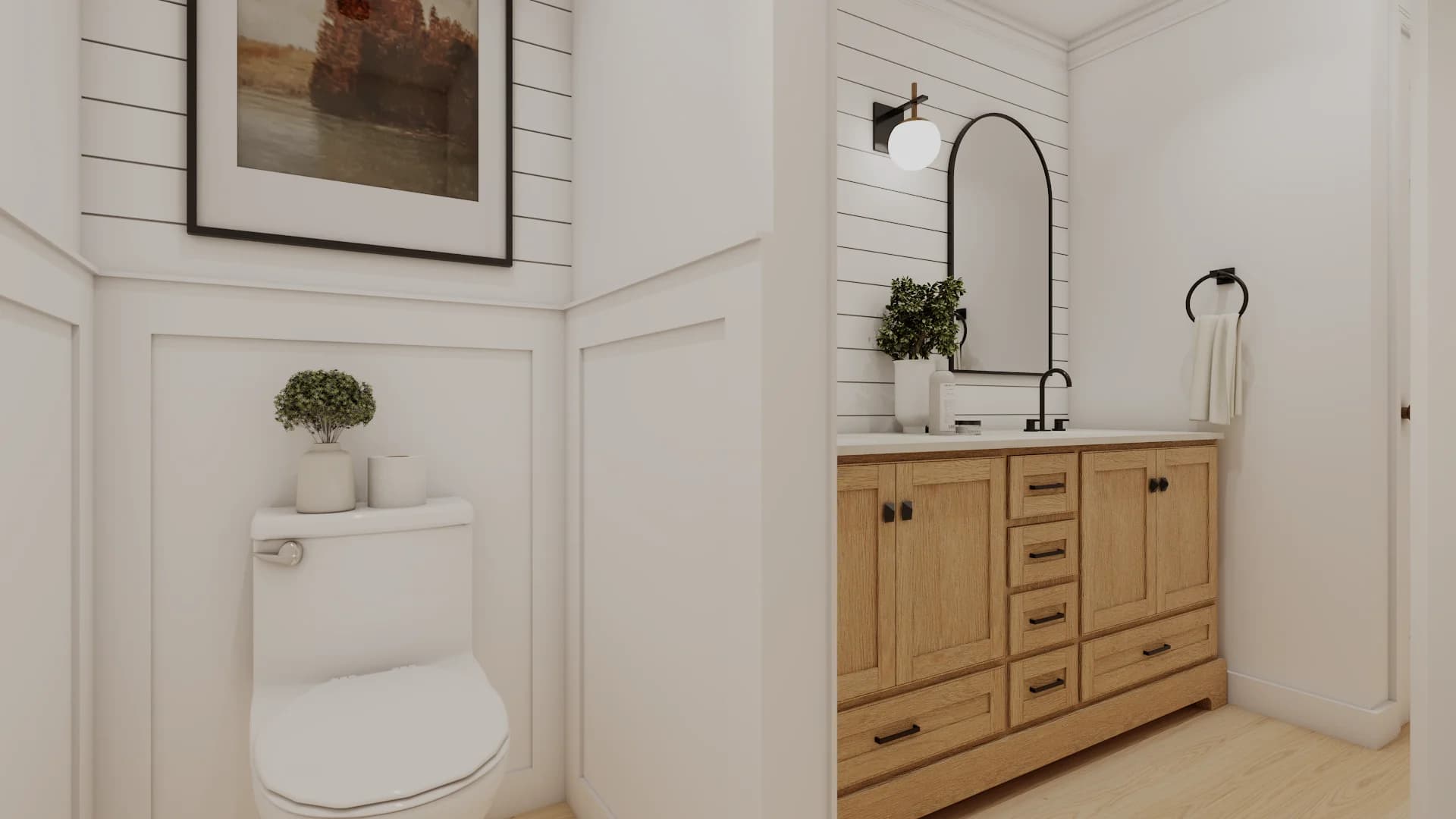 Wainscoted toilet alcove with panel molding and landscape art, oak shaker vanity with arched mirror