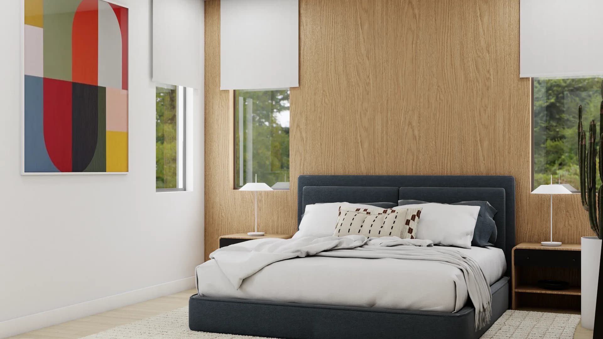 Angled view of navy bed with abstract colorful art on white wall and oak panel headboard