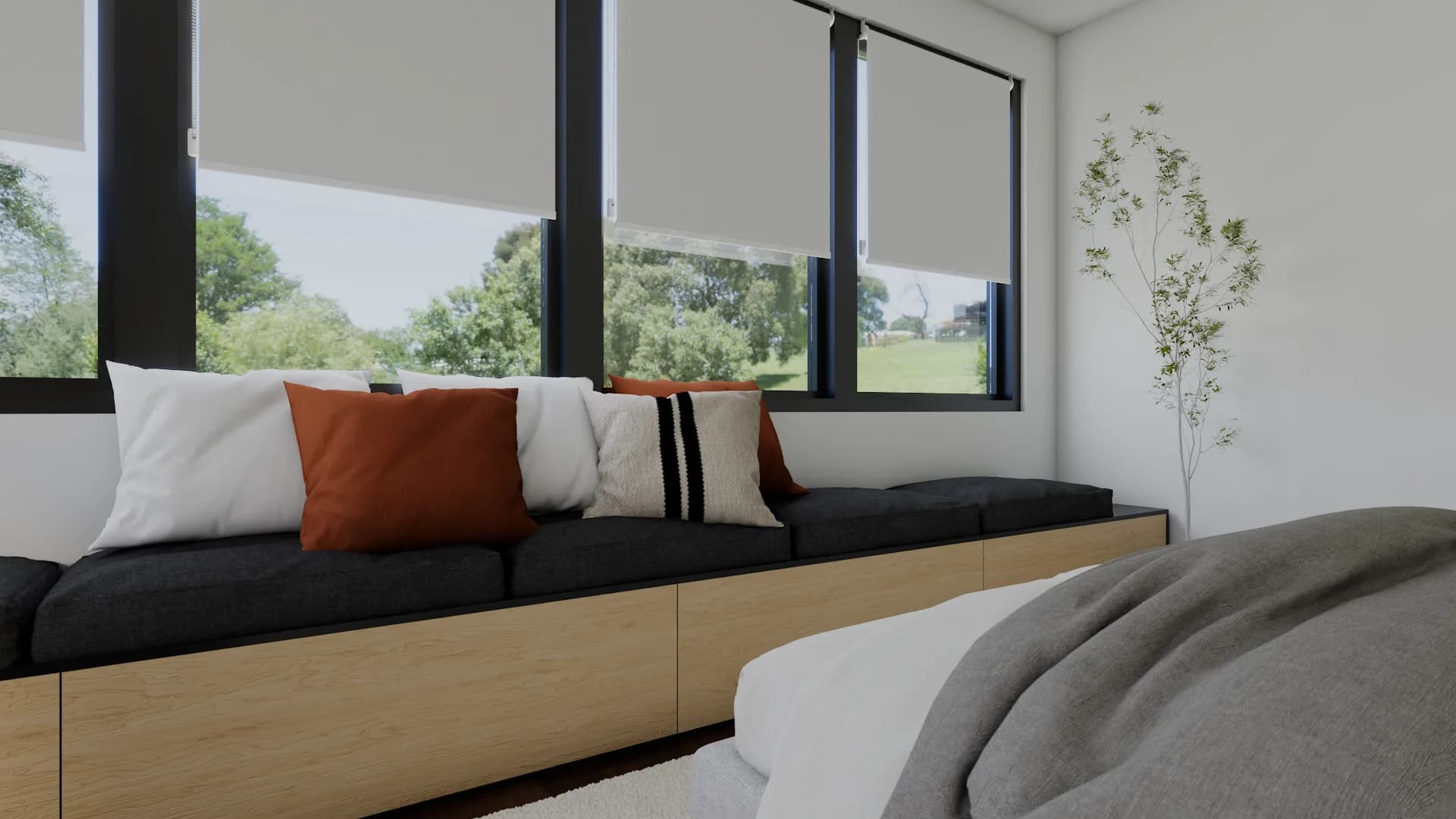 Close-up of built-in window seat with terracotta, white, and charcoal pillows under roller-blind win