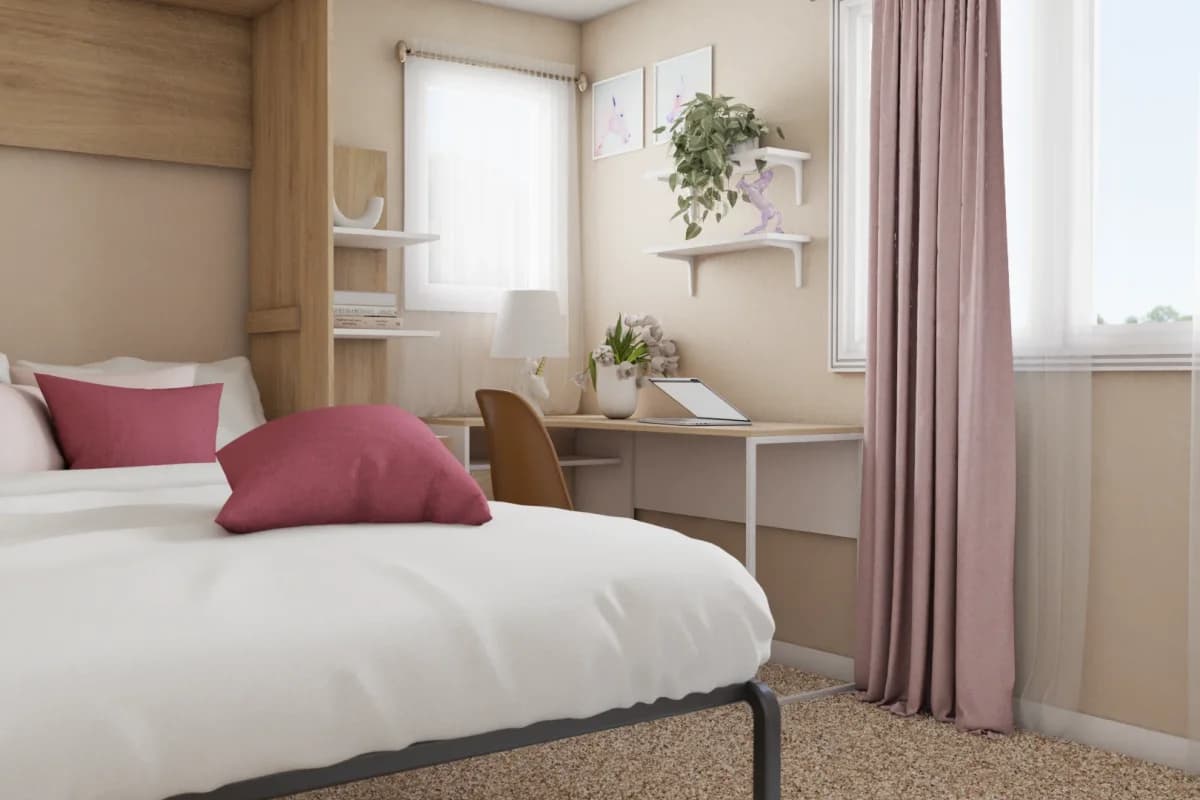 Wide bedroom view showing oak panel headboard beside a corner built-in desk with white floating shelves and trailing plant, raspberry pink pillow accents on white bedding