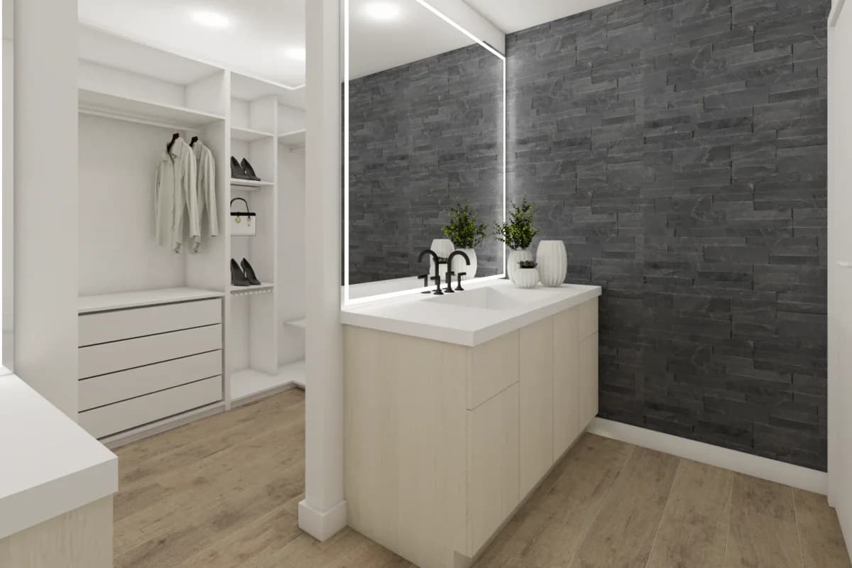 White open-shelf closet with hanging rail and drawers beside a white vanity island in front of a dark charcoal stone ledger accent wall and oversized mirror