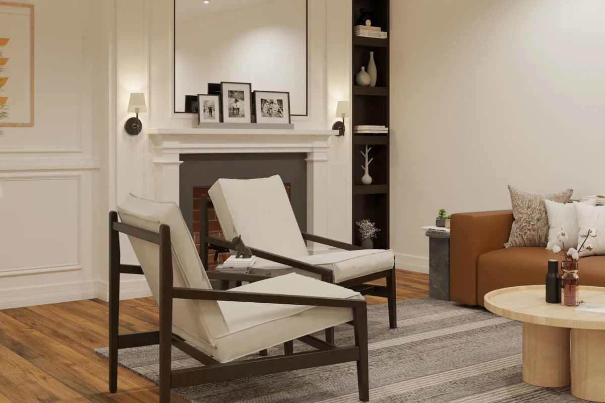 White plaster fireplace with sconces on mantle flanked by narrow dark shelving unit in a transitional sitting room with linen chairs and tan leather sofa