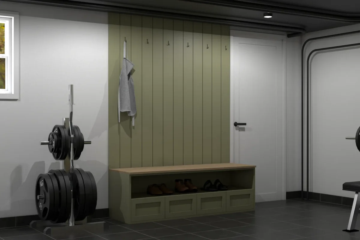 Sage green shaker locker bench with oak top and shoe cubby in a garage gym, flanked by a barbell weight rack and dark ceiling