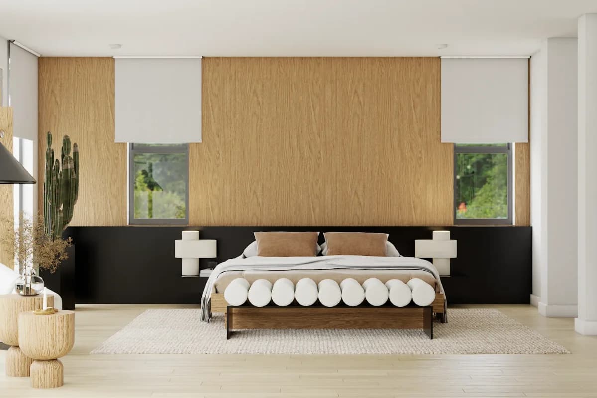 Full-height oak wood panel headboard wall with integrated low black platform nightstands flanking bed in a minimalist japandi primary bedroom with white roller shades