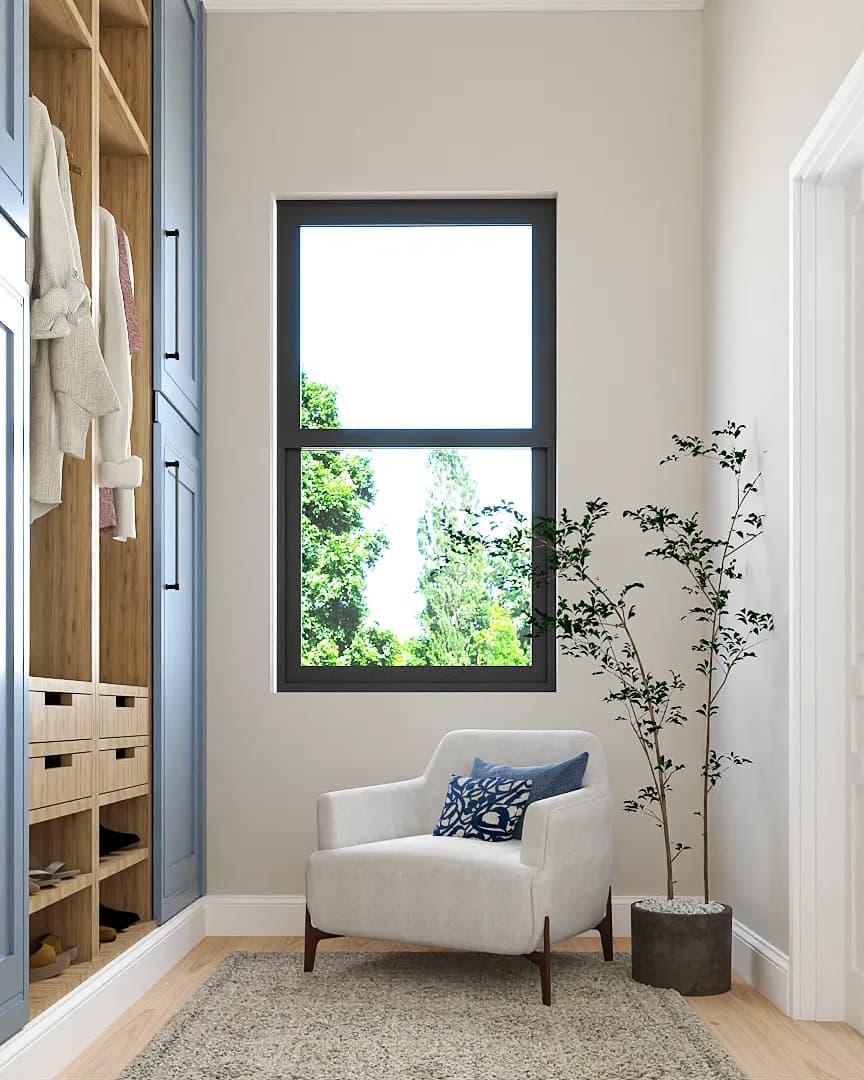 White armchair with blue pillow beside large window and open oak closet shelving