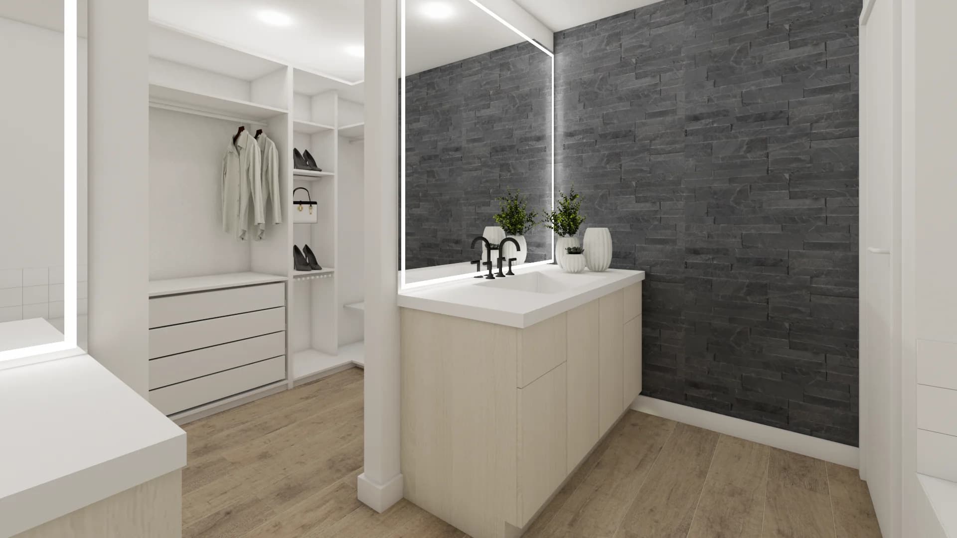 Walk-in closet vanity island with white quartz countertop, matte black fixtures, and a floor-to-ceiling charcoal stacked-stone accent wall behind a large frameless mirror, by Debora Interiors