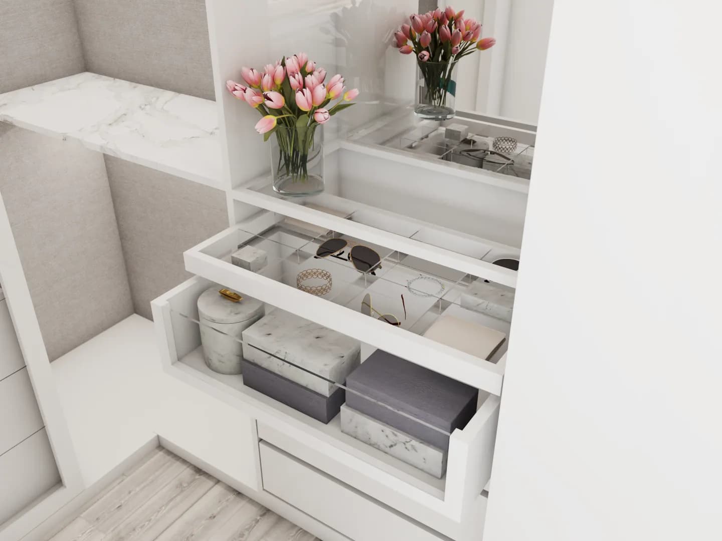 White built-in closet vanity area with glass-top accessory drawer holding sunglasses and jewelry, marble countertop, pink tulips in a glass vase, and gray storage boxes below.