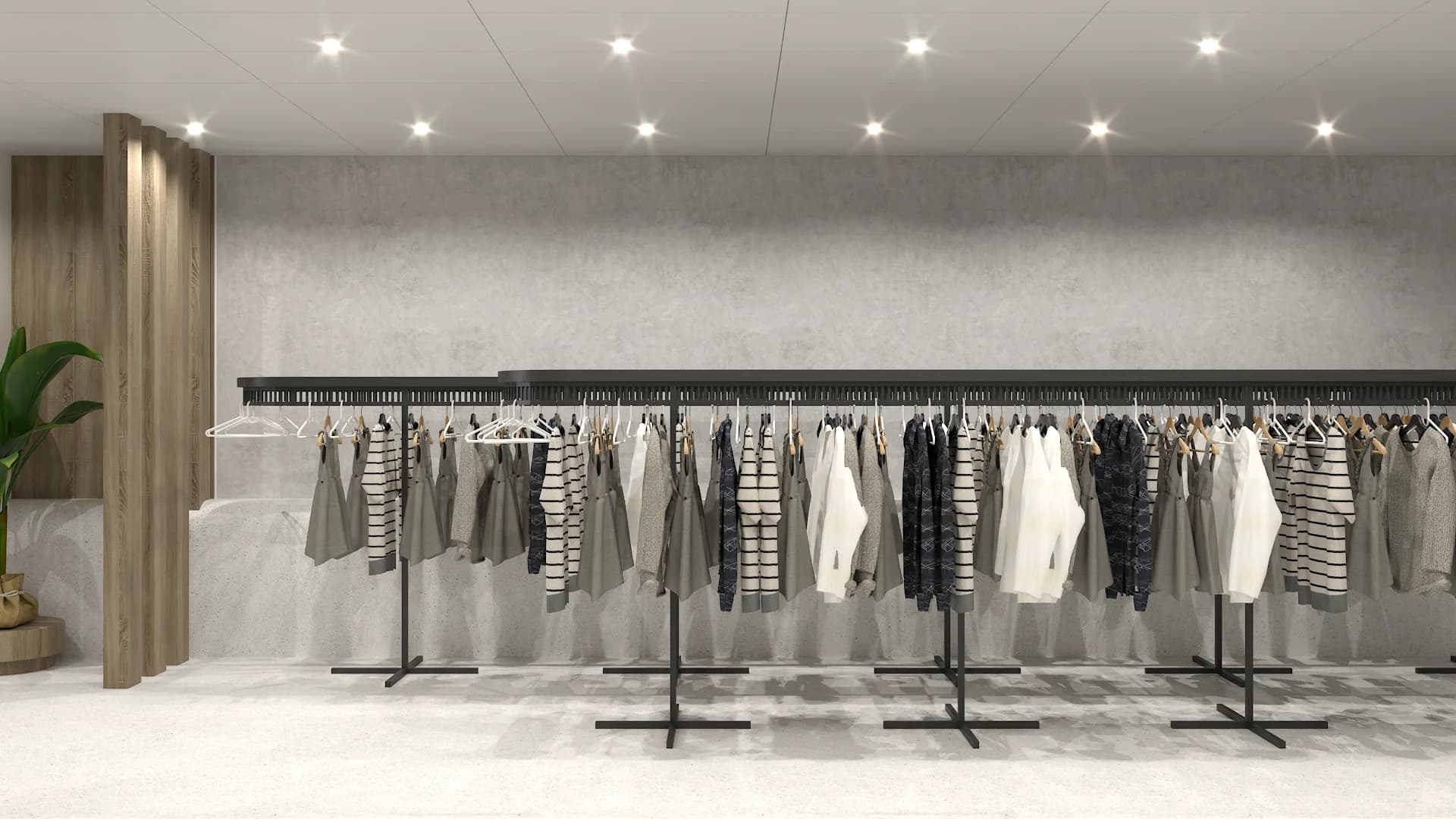 Angled view of double clothing racks against concrete wall with recessed spotlights and oak column