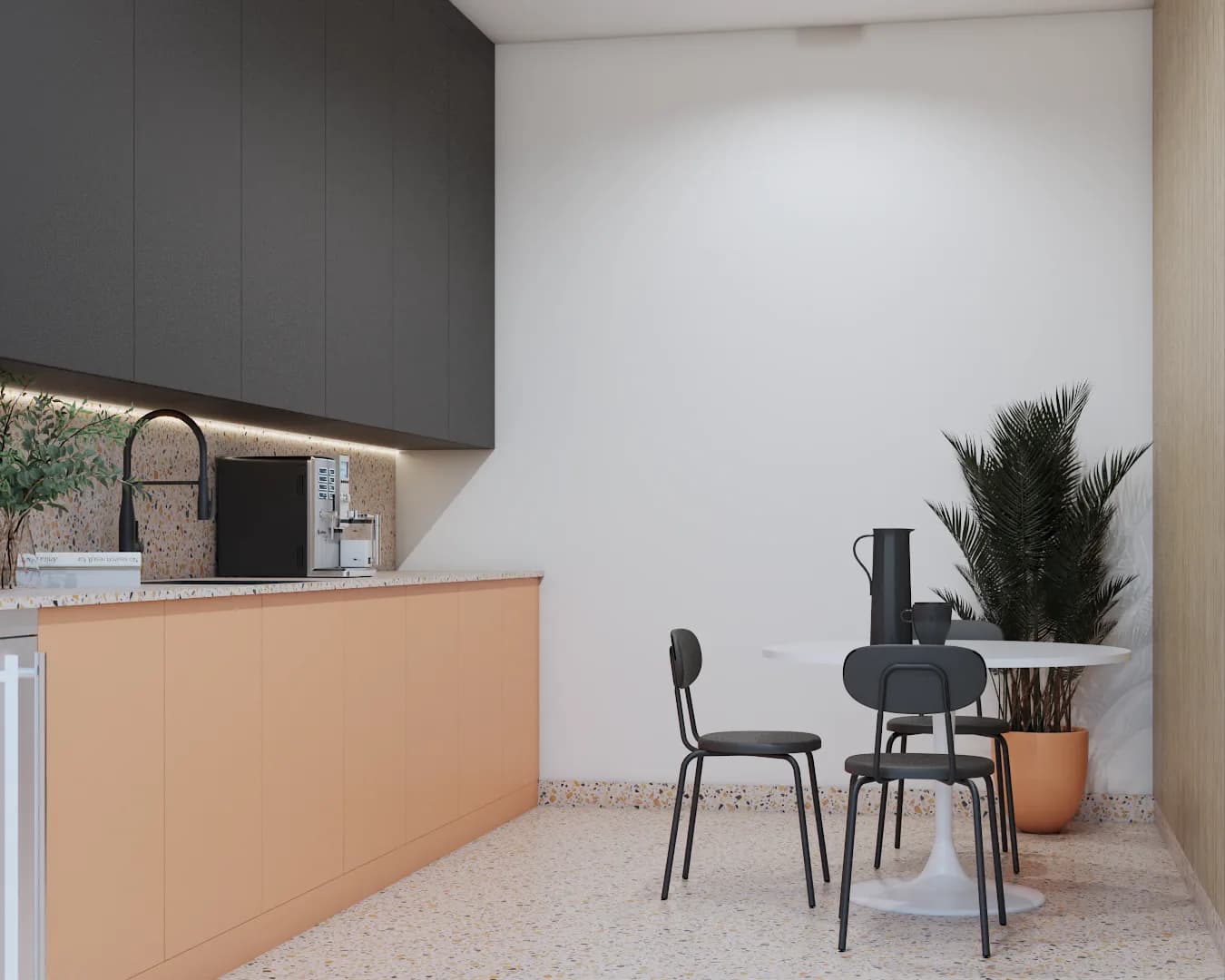 Break room with white tulip table, black chairs, and charcoal kitchenette counter