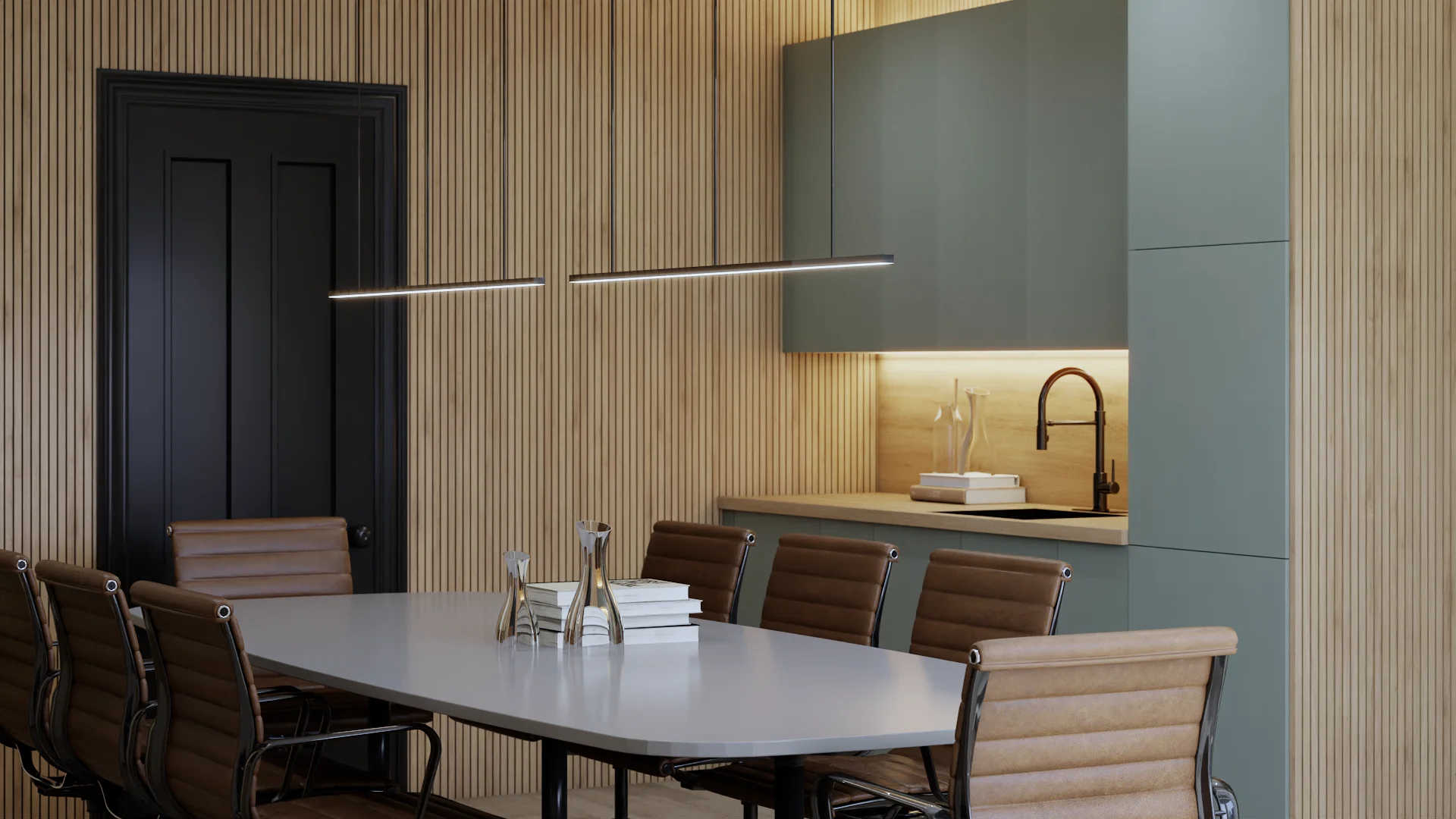 Sage green flat-front upper and lower cabinets forming a built-in kitchenette niche with warm oak wood backsplash, under-cabinet LED strip lighting, matte black gooseneck faucet, wood countertop, white oval conference table with tan leather chairs in foreground