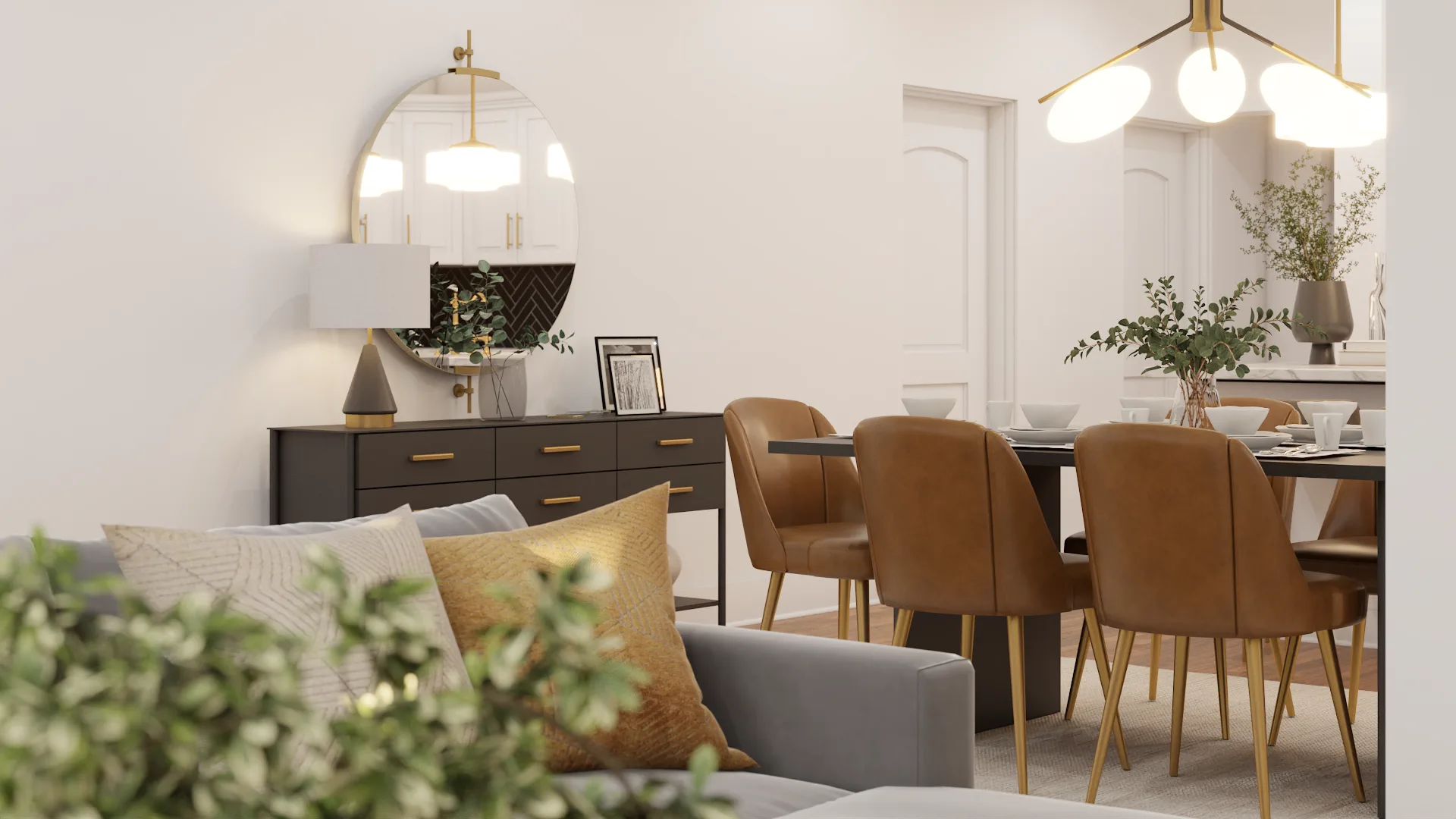 Dark sideboard with brass pulls and round brass mirror beside gray sofa with gold pillow