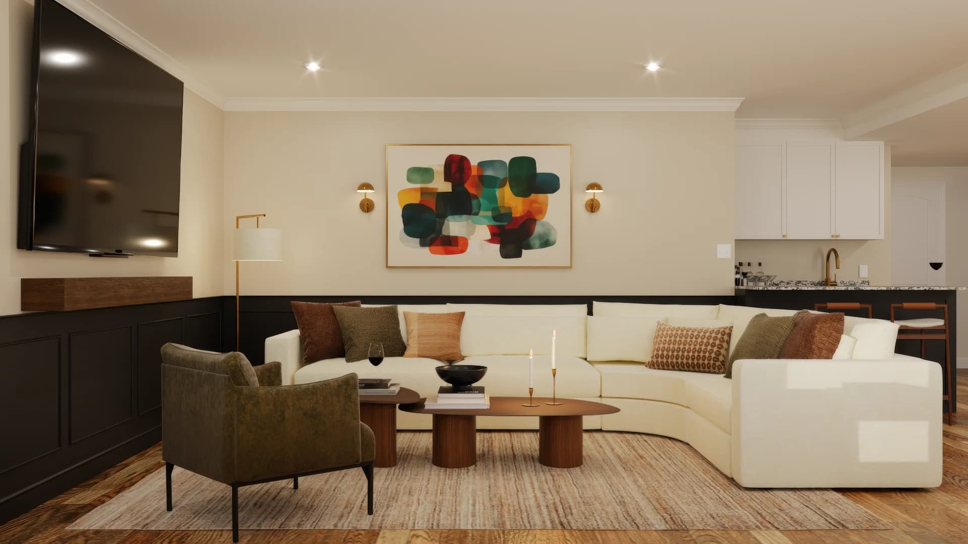 Basement lounge with cream curved sectional, olive green accent chair, walnut oval coffee tables, brass floor lamp, black wainscoting trim, large abstract teal and rust painting flanked by brass wall sconces, and bar area with white cabinets.