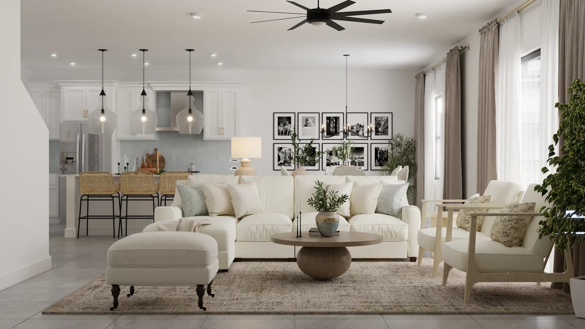 Open-plan living room with cream sectional, round wood coffee table, and white kitchen with rattan stools visible