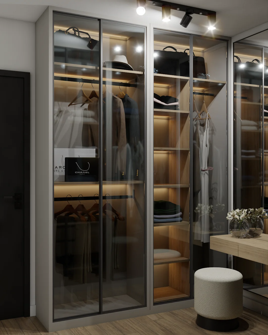 Walk-in closet with amber-glass wardrobe, integrated lighting, hanging rods, and vanity area