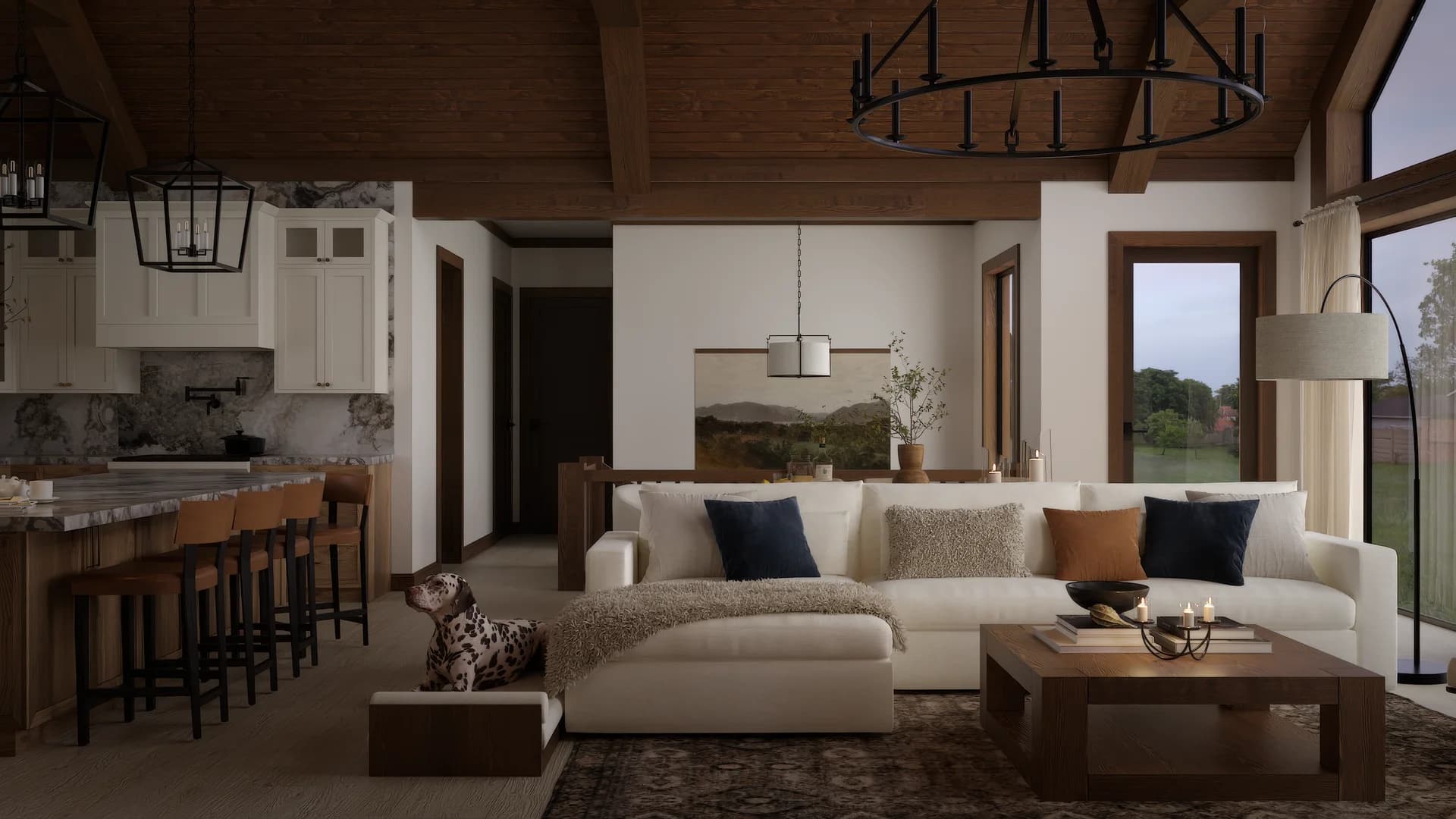 Atmospheric farmhouse living and kitchen view with vaulted wood ceiling, cream sectional, walnut coffee table with candles, kitchen island beyond, and hallway to private rooms