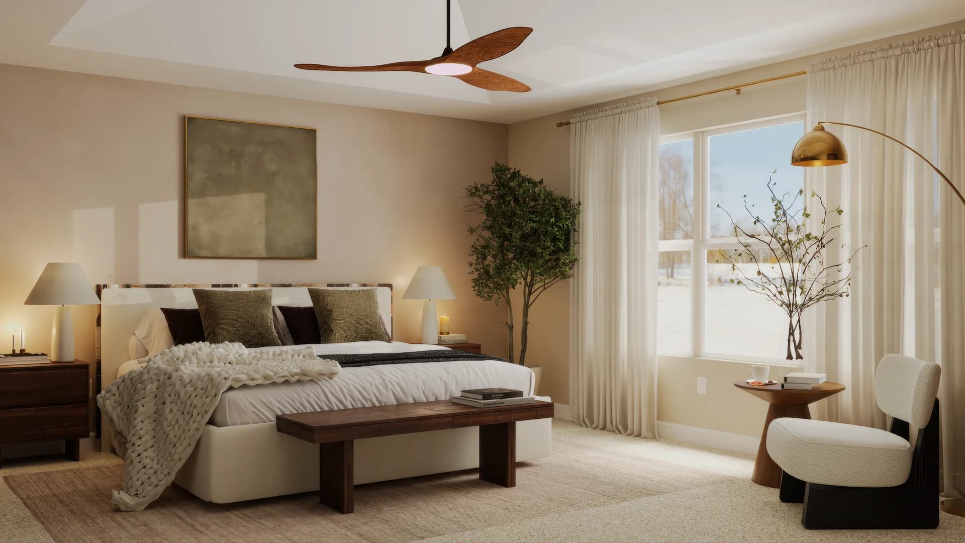 Master bedroom wide view with wood ceiling fan, cream upholstered bed, walnut nightstands with table lamps, olive and dark brown throw pillows, chunky knit blanket, walnut bench, abstract canvas artwork, potted tree, sheer curtains, and brass arc floor lamp with reading chair.