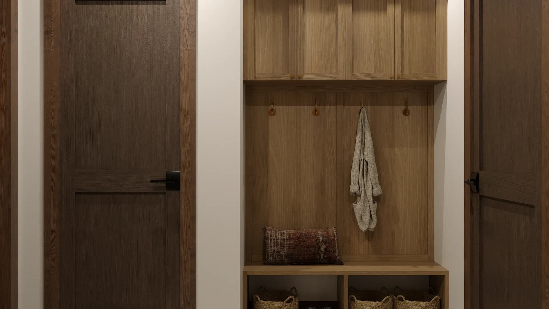 Mudroom entry with built-in oak bench, upper cabinets, coat hooks, three lower cubbies with woven seagrass baskets, flanked by dark stained wood panel doors