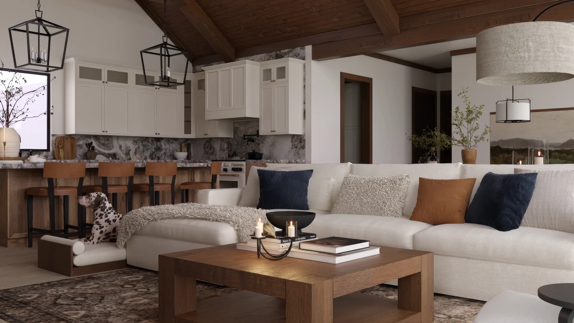 Open-plan living area from sectional perspective showing kitchen island with leather stools, iron lantern pendants, drum shade lamp, navy and cognac pillows on cream sofa