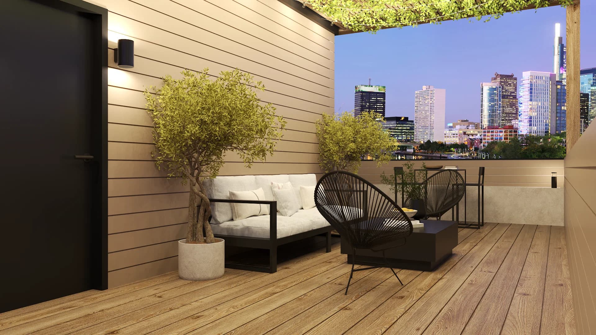 Rooftop terrace at evening with cream sofa, black Acapulco chair, olive tree, and city skyline