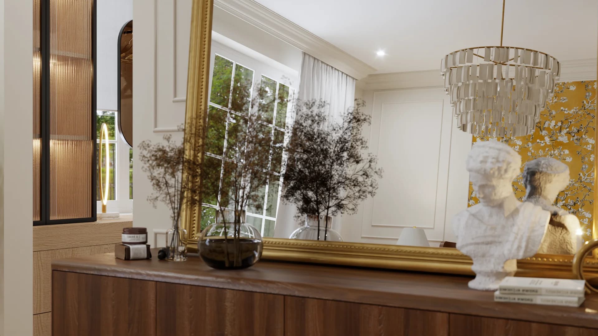 Walnut credenza detail with gold-framed leaning mirror, smoked glass globe vase, dried branch stems, white classical bust sculpture, and crystal chandelier overhead against mustard floral wallpaper