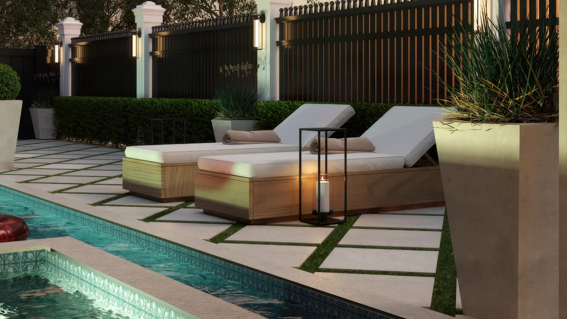 Poolside lounge chairs on stone pavers with grass inlay, overlooking mosaic tile pool and gabled cabana