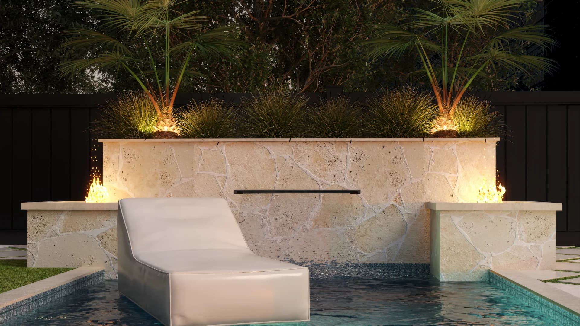 Ledge lounger on pool tanning shelf with fire bowls on stone retaining wall and palm landscaping at dusk
