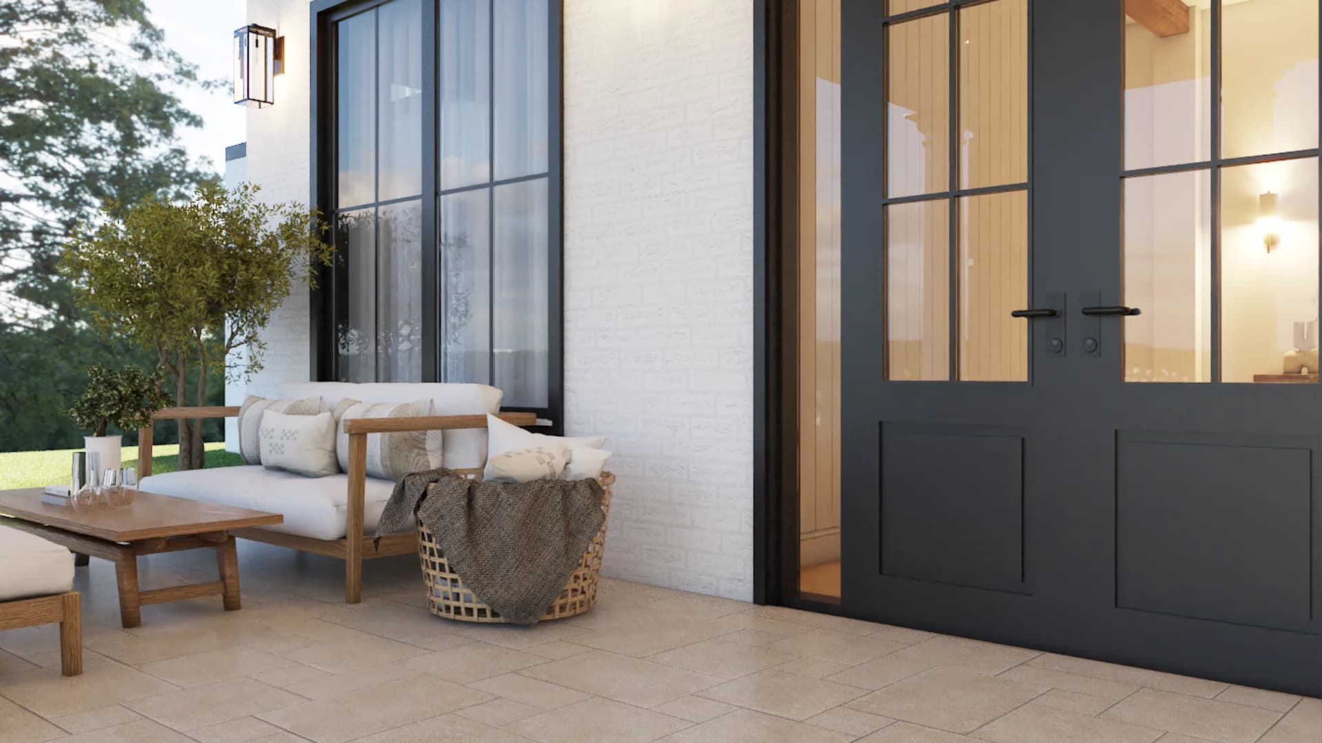 Side yard patio with teak outdoor sofa, wicker lounge chair with fur throw, teak coffee table, black sconce, white brick wall, and dark steel-frame French door entry by Debora Interiors