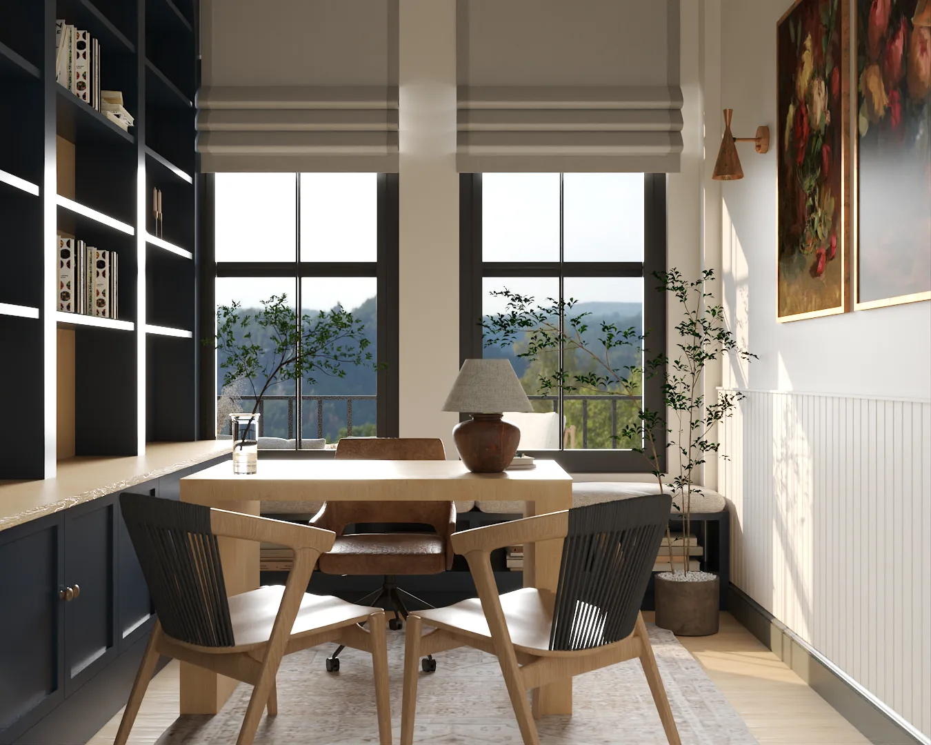 Oak desk with black woven chairs facing tall black-framed windows with roman shades and a floral oil painting on the white paneled wall with brass wall sconce.