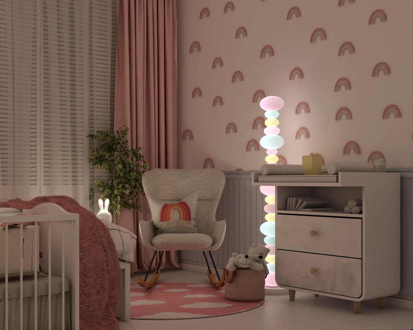 Evening view of pastel stacked sphere floor lamp glowing beside white changing dresser, gray rocker, and rainbow wallpaper accent wall