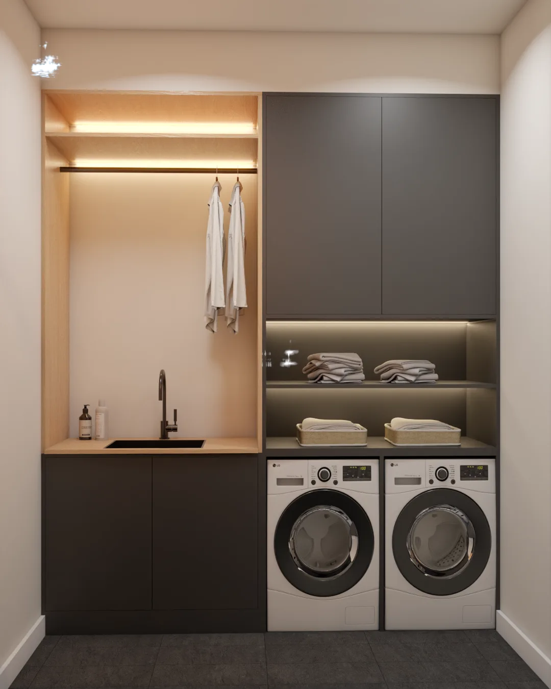 Compact laundry nook with charcoal flat-front cabinets, oak-paneled hanging alcove with LED strip lighting, black undermount sink, open linen shelves, and side-by-side front-load washer and dryer