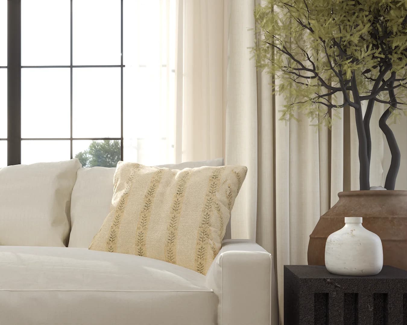 Close-up of cream sofa arm with patterned linen pillow and potted olive tree.