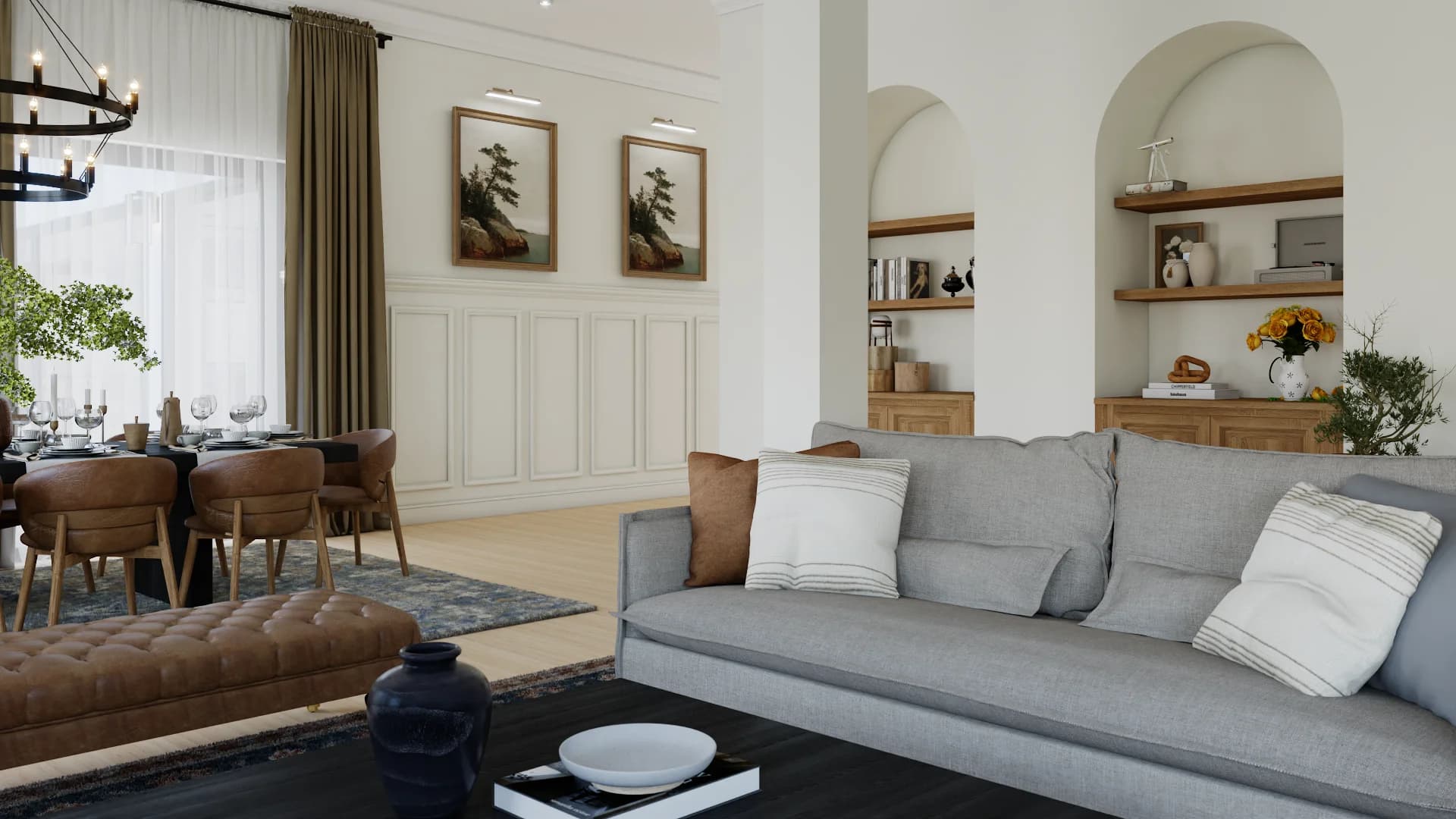 Open-plan living and dining with paired arched plaster niches, oak shelving, gray linen sofa, cognac leather chairs, wainscoting, and iron chandelier