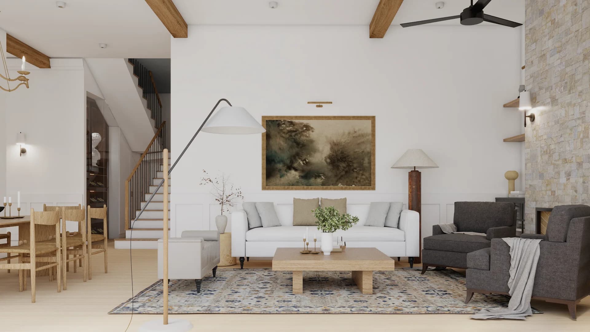 Living room from staircase side showing exposed timber beams, stone fireplace column, white linen sofa, blue-cream Persian rug, and landscape oil painting