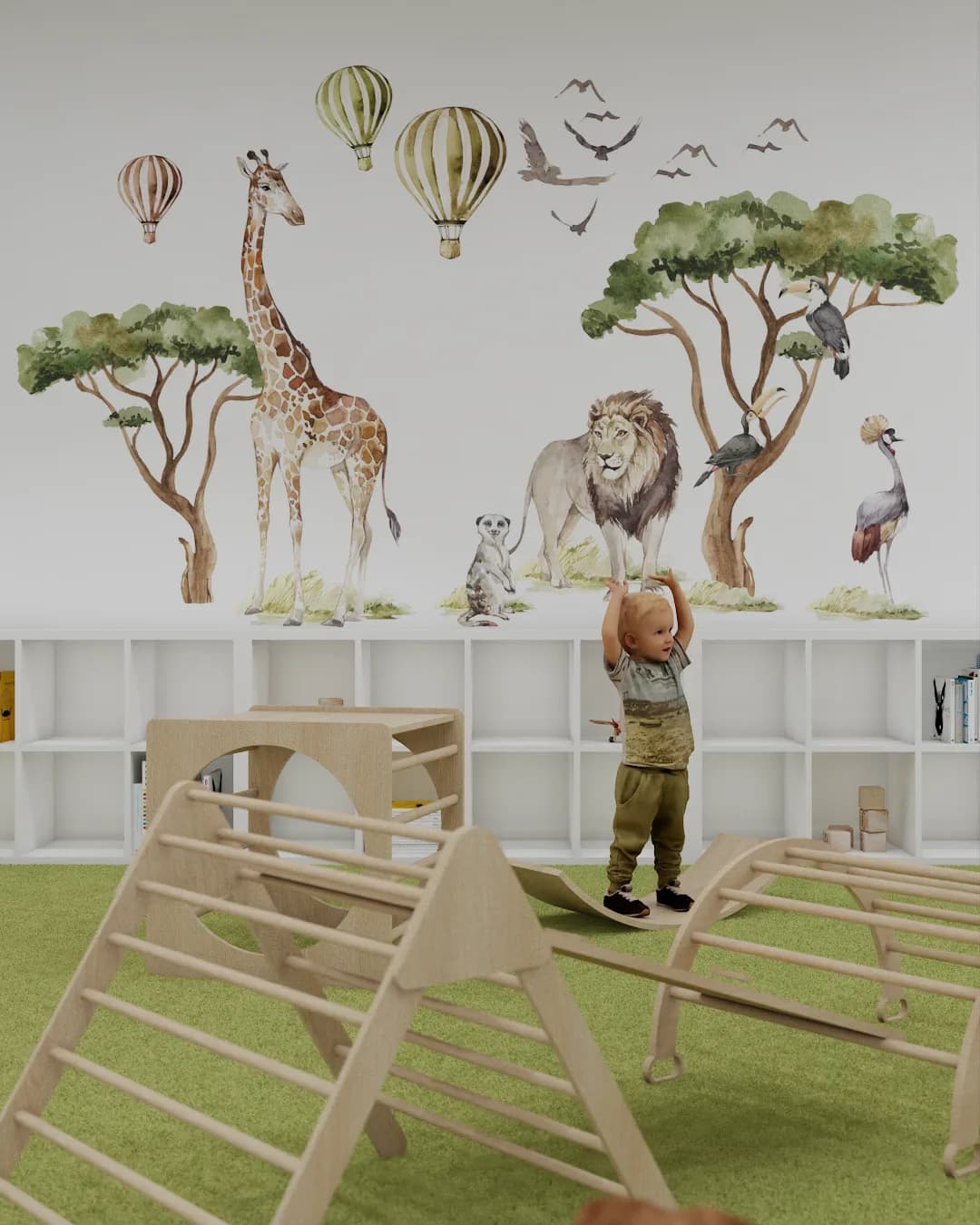 Safari mural wall with giraffe, lion, and hot air balloons above Pikler climbing structures