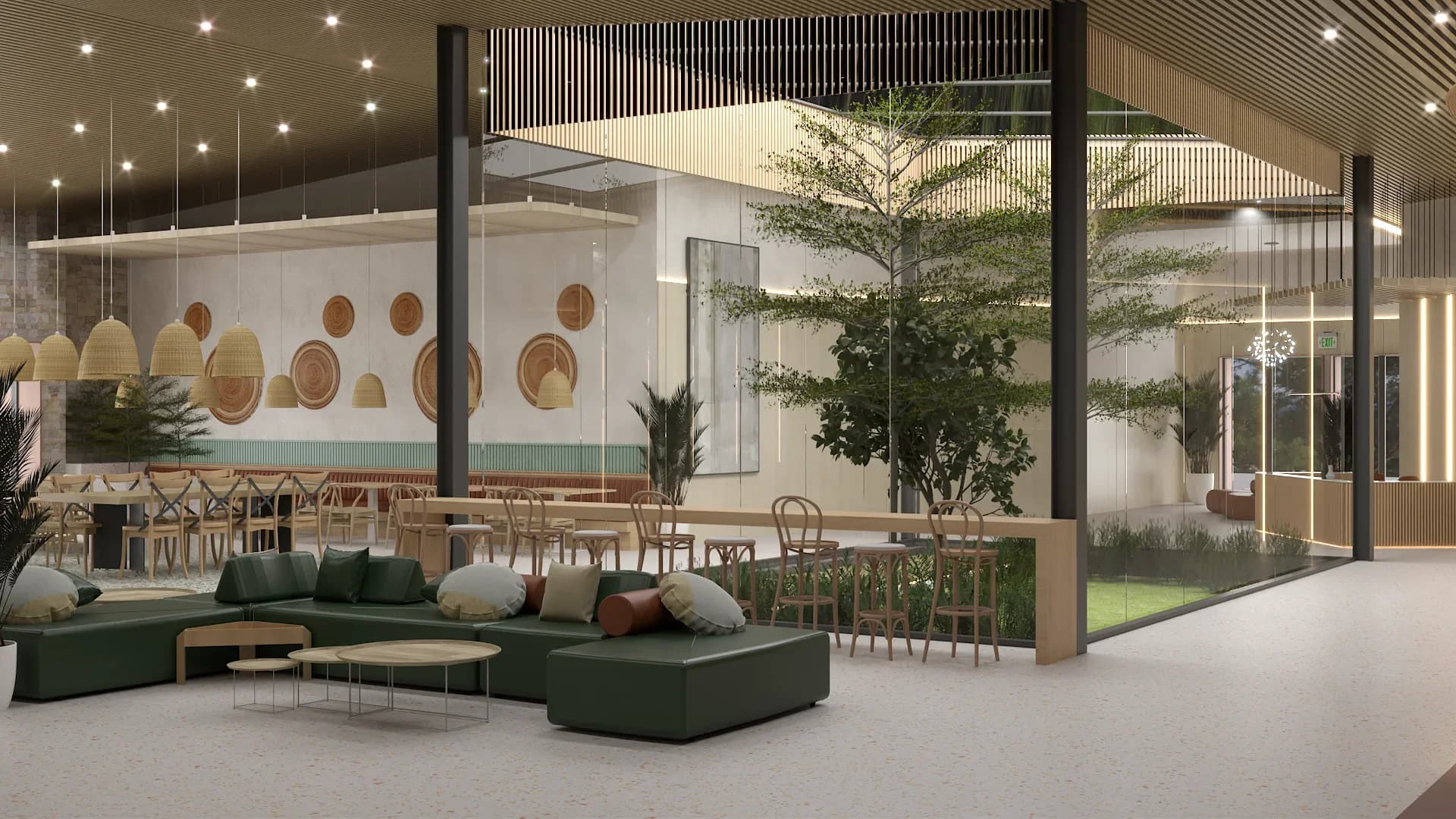 Restaurant lounge zone with dark green modular sectional sofa and throw pillows, small round wooden coffee tables, woven basket pendant lights, decorative round wooden wall plates, sage green fluted wainscoting, glass-enclosed indoor garden with a tree, and terrazzo flooring