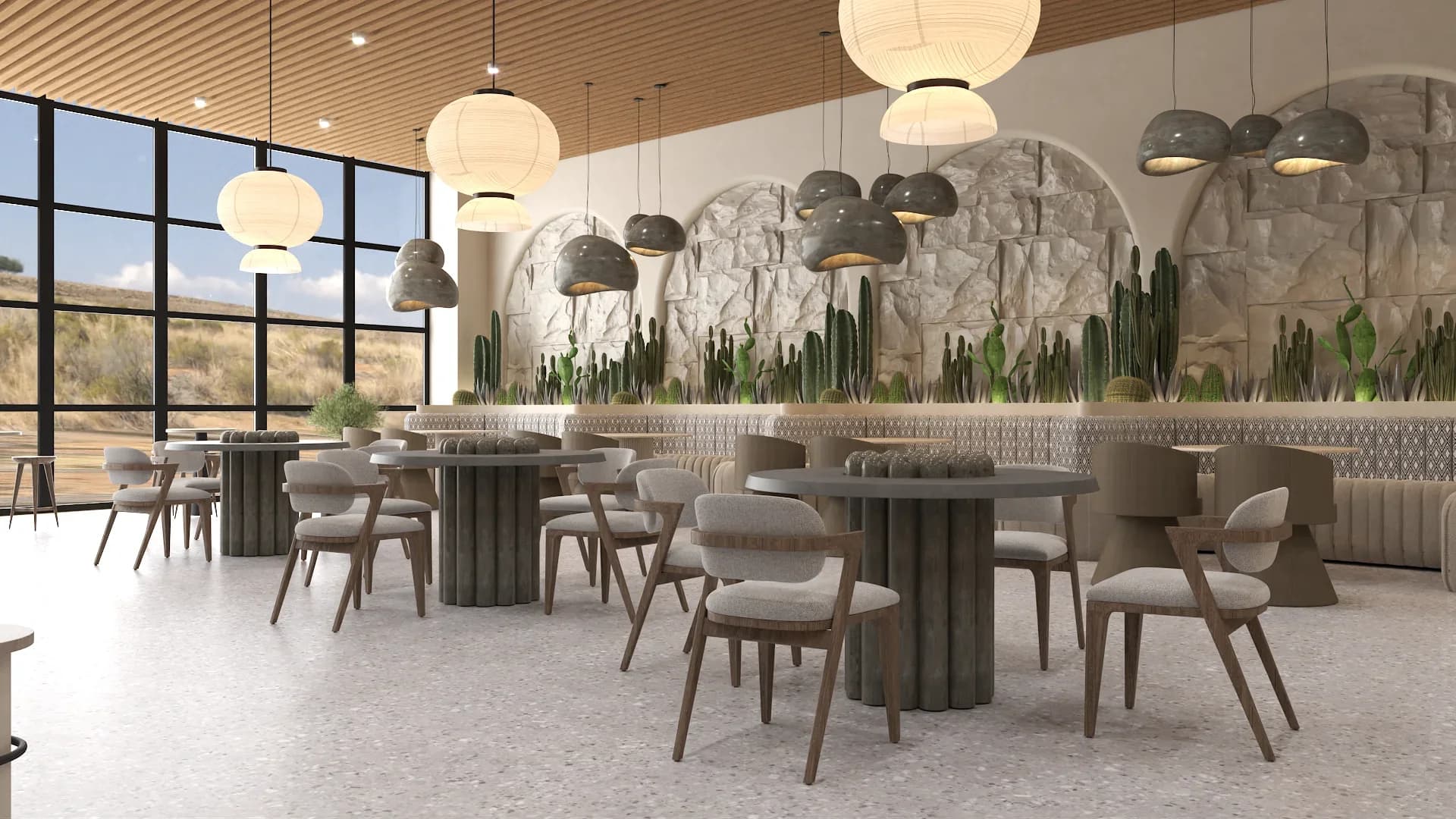 Restaurant dining room with round dark wood fluted-base tables and taupe upholstered chairs, multiple stone arches filled with green cactus plantings along the back wall, large paper lantern and gray cluster pendant lights, patterned tile accent strip, and light terrazzo flooring with wood slat ceiling