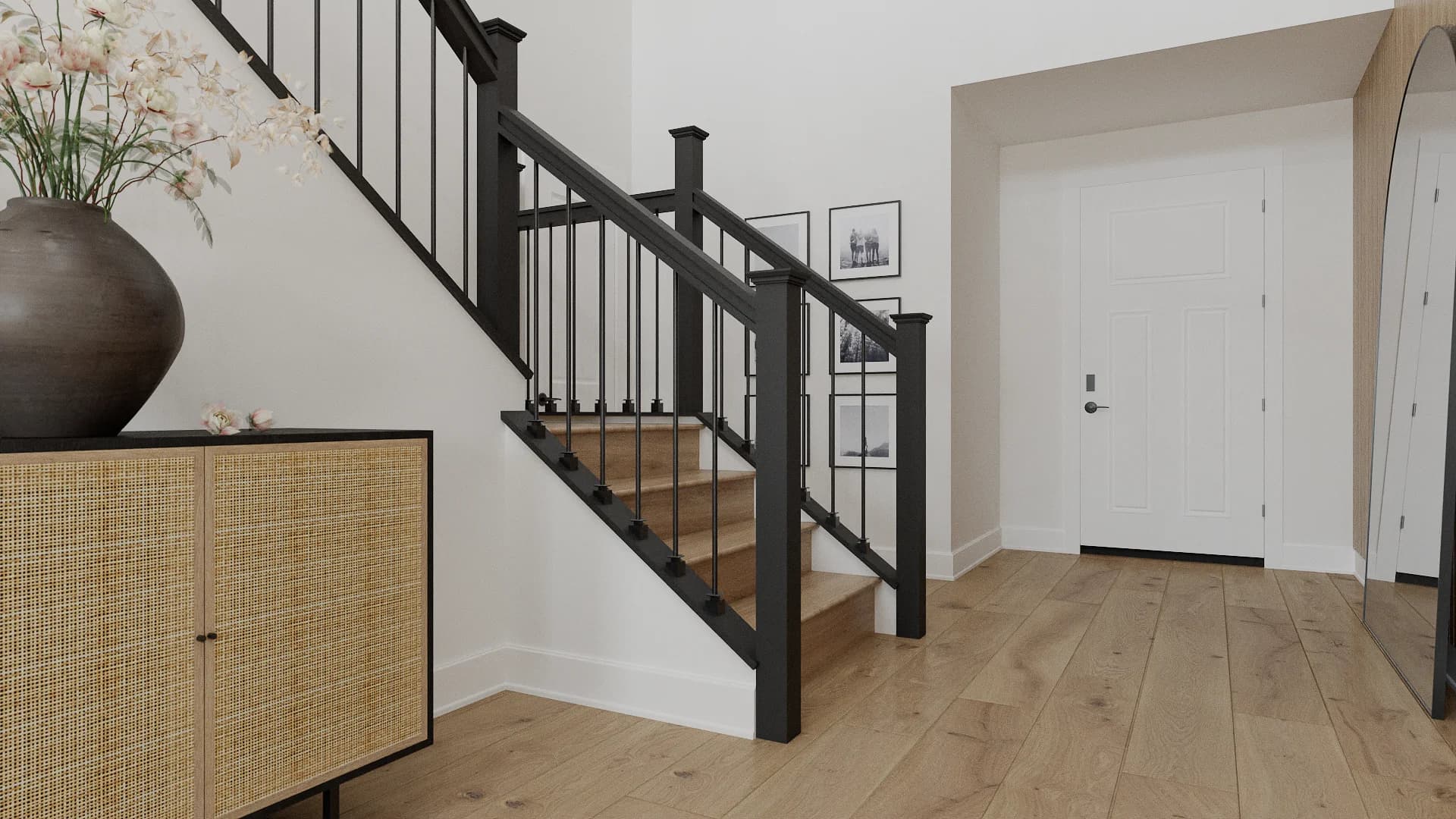 Staircase entry view with black iron square balusters, oak treads, rattan console, and dried botanicals