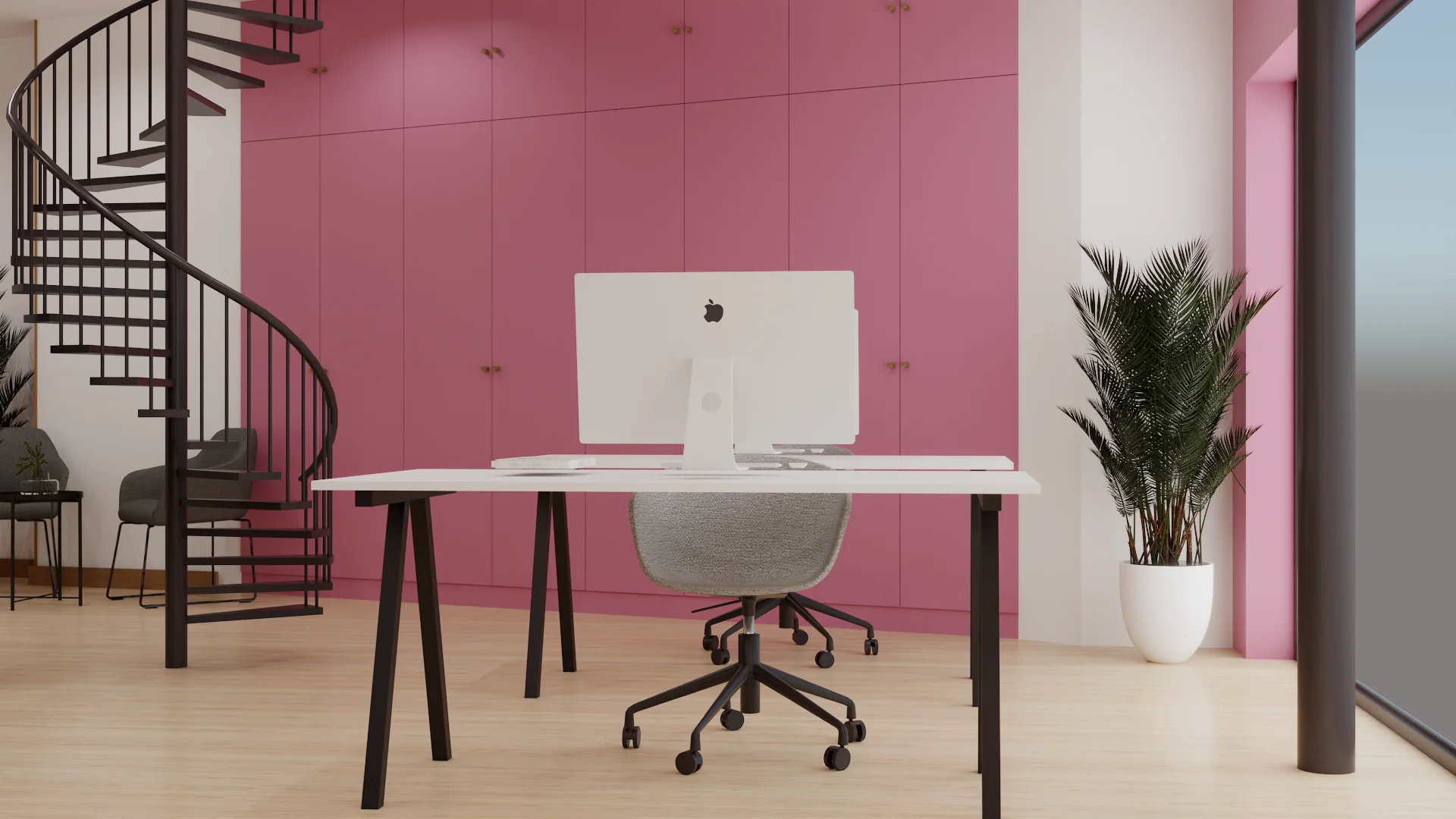 Single iMac desk against pink paneled wall with spiral staircase and palm plant
