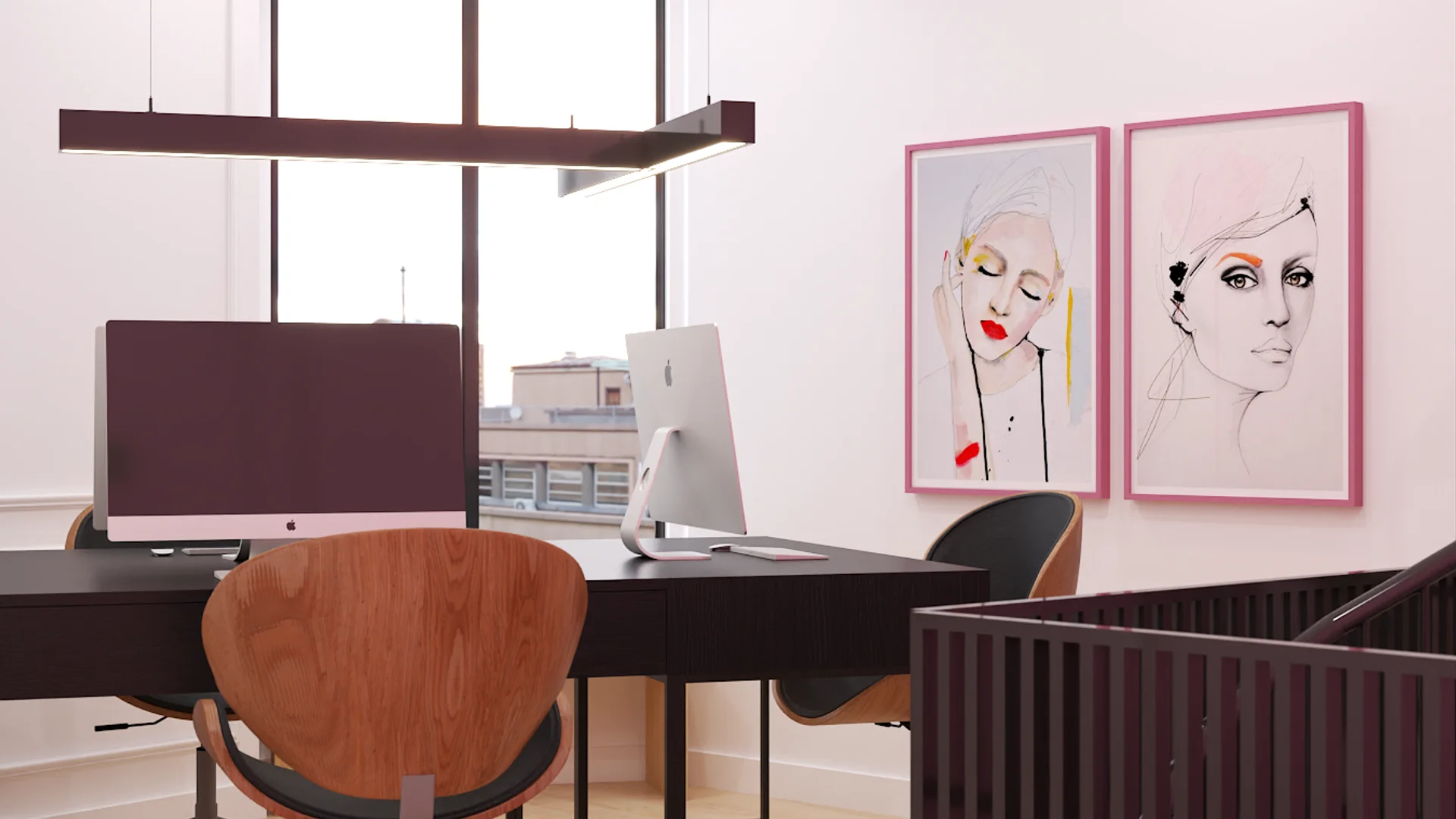 Mezzanine desk with two iMacs, walnut chairs, and pink-framed fashion art